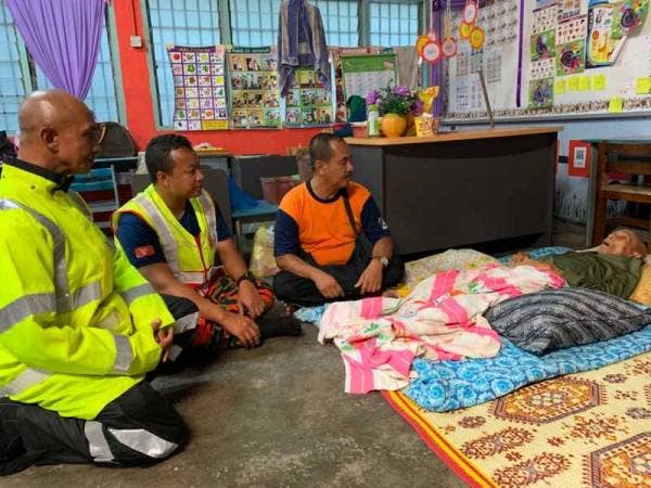 Rafain (dua dari kiri) dan Azman (tiga dari kiri) melihat keadaan Salleh yang terlantar di PPS di sini.