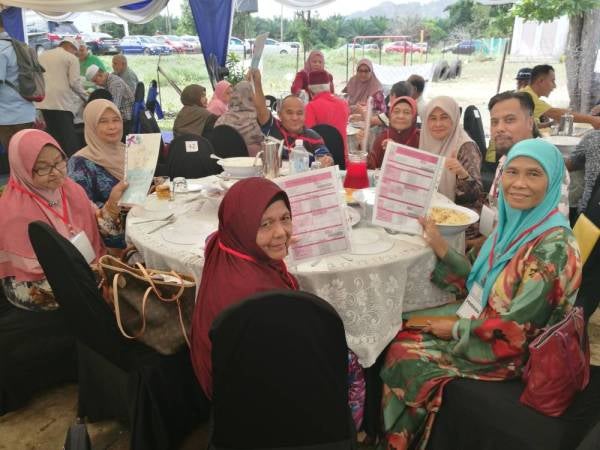 Fatimah (depan) bersama sebahagian penerima surat hak milik tanah yang diserahkan menteri besar sempena Majlis Ramah Mesra dan Penyerahan Surat Hak Milik Kampung Seri Mahkota di sini hari ini.