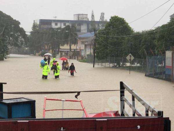 Anggota penyelamat yang turut sama mengharung air banjir bagi menyelamatkan mangsa.