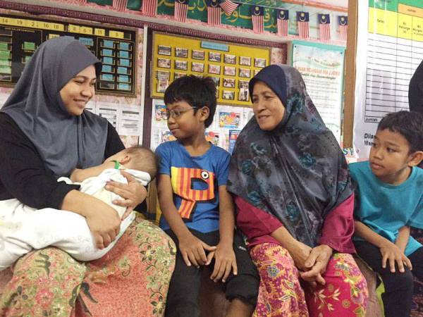 Suriani bersama anaknya yang berusia sembilan bulan dan anak berusia sembilan tahun yang masih dalam pantang selepas berkhatan.