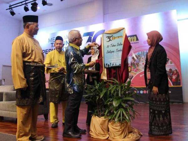 Hussamuddin (tengah) ketika merasmikan pelancaran buku '30 Tahun Dalam Dakapan Tarbiah'. Turut kelihatan, Abdullah (kiri). - Foto Haluan