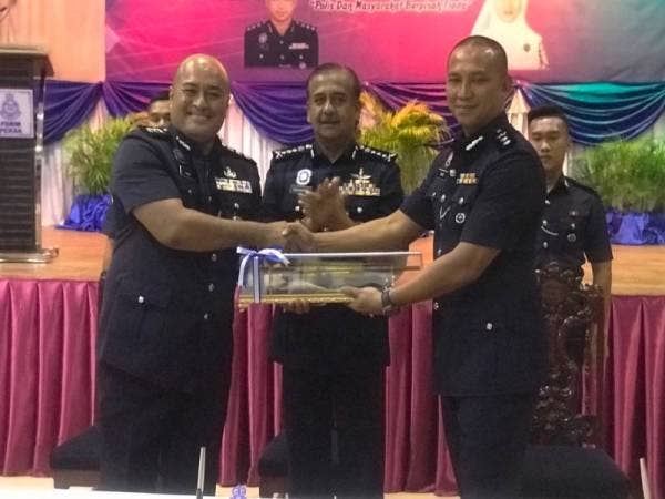 Razarudin (tengah) menyaksikan majlis serah terima tugas Ketua Polis Daerah Manjung antara Muhammad Hanif (kiri) kepada Nor Omar (kanan) hari ini.