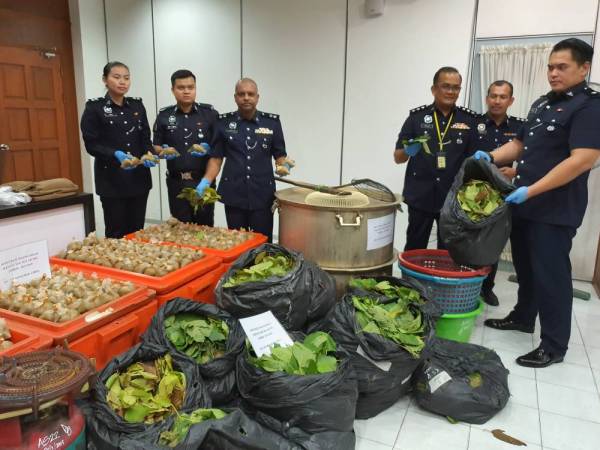 Anbalagan (tiga dari kiri) menunjukkan bungkusan air dan daun ketum yang dirampas.