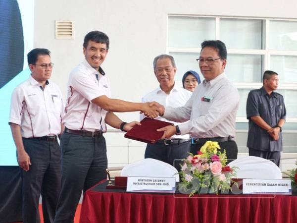 Muhyiddin (tiga dari kiri) menyaksikan majlis penyerahan kompleks ICQS antara Pengarah Urusan Kumpulan DRB-Hicom, Datuk Seri Syed Faisal Albar Syed Ali Rethza Albar (dua dari kiri) dan Ketua Setiausaha KDN, Datuk Jamil Rakon di sini hari ini.