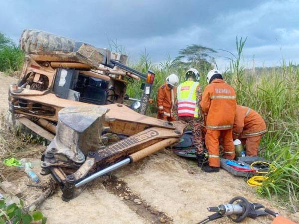 Anggota bomba ketika sedang berusaha mengeluarkan mangsa selepas dihempap jentera berat berkenaan.