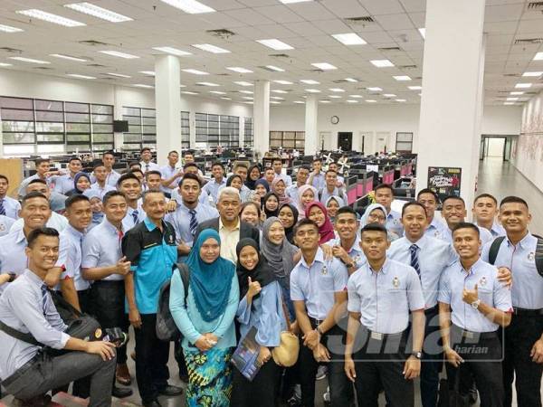 Abdul Rahman (lima dari kiri) dan warga UPNM bergambar di ruangan Sinar Harian.