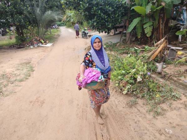 Ramlah membersihkan pakaian di sungai berhampiran secara berperingkat.