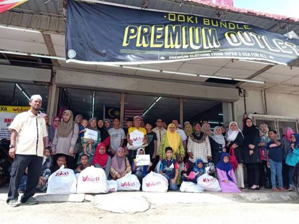 Andansura (tengah) bersama sebahagian penerima program kembali ke sekolah dan penyampaian baucer pembelian barangan kelengkapan persekolahan 2020 DUN Beserah di Pasaraya Sakan semalam.