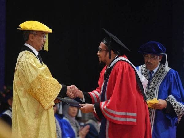 Yang di-Pertuan Agong berkenan menyampaikan Anugerah Canselor kepada Graduan Ijazah Pentadbiran Perniagaan (MBA) Amir Suhaimi Hassan pada Majlis Konvokesyen keenam DRB-Hicom University of Automotive Malaysia hari ini. - Foto Bernama