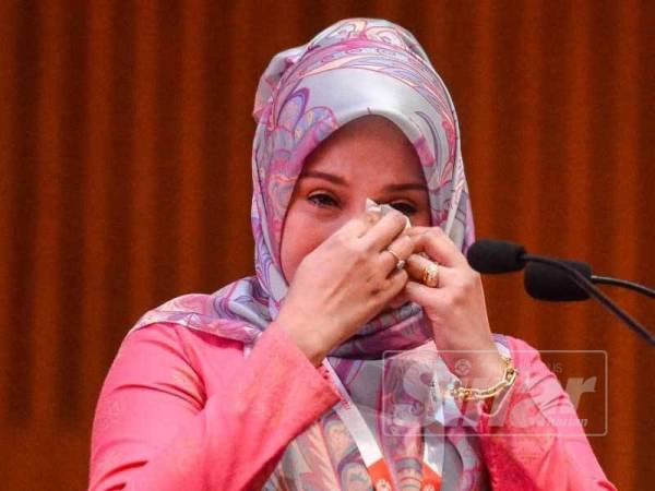Anne Ngasri tidak dapat menahan sebak ketika berucap pada Perhimpunan Agung UMNO 2019 hari ini. - FOTO ZAHID IZZANI