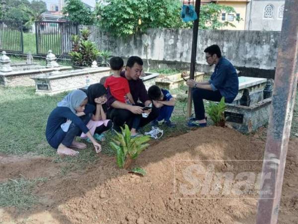 Keluarga menziarahi pusara Daud di Tanah Perkuburan Islam Setia Budi, Kampung Aman hari ini.