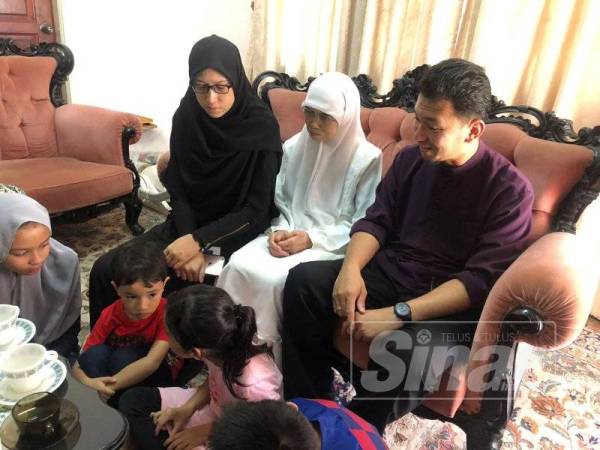 Halimah (tengah) bersama anak dan cucunya kelihatan tenang ketika ditemui di rumahnya di Kota Bharu hari ini.