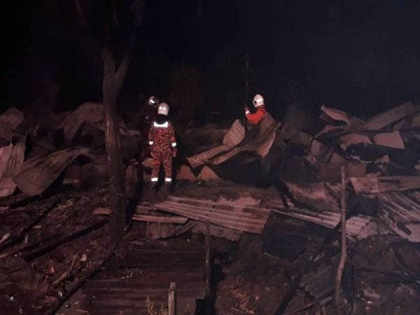 Anggota bomba melakukan pemeriksaan lanjut selepas memadam kebakaran rumah kongsi berhampiran Jeti Tanjong Gemok di sini awal pagi tadi. - Foto Ihsan BOMBA
