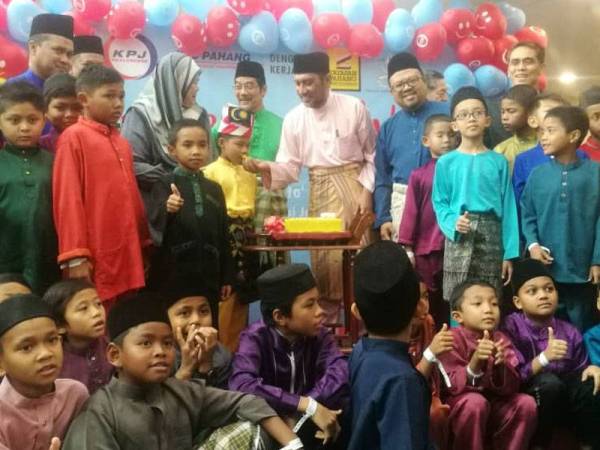 Syed Ibrahim (tengah) menyuapkan pulut kuning kepada salah seorang peserta khatan.