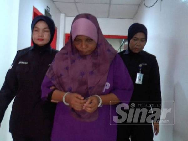 Roslina diiringi polis sewaktu hadir ke Mahkamah Sesyen Kuala Terengganu hari ini.