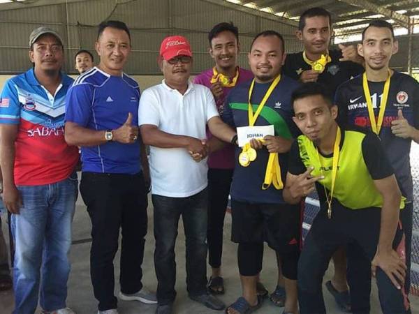 Ahmad Shuhor (empat dari kiri) menyampaikan hadiah kepada Pasukan Taman Maran Jaya yang memenangi kejphanan futsal itu