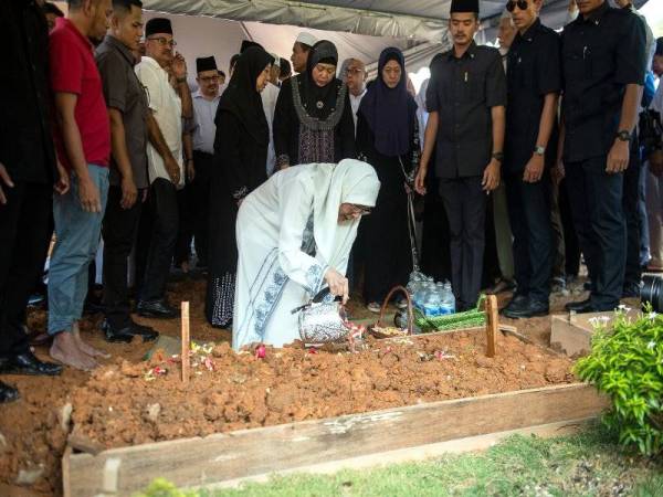 Wan Azizah menyiram air mawar di pusara bapanya Dr Wan Ismail Wan Mahmood, 93, di Tanah Perkuburan Islam Ukay Perdana hari ini. - Foto Bernama