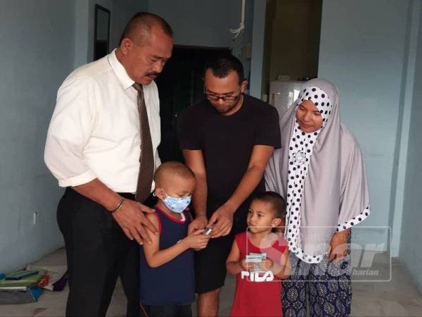 Keluarga Md Roslin menerima kunjungan daripada Setiausaha Politik Perdana Menteri, Abu Bakar Yahya (kiri) yang turut menyampaikan salam serta sumbangan mewakili Perdana Menteri, Tun Dr Mahathir Mohamad baru-baru ini.