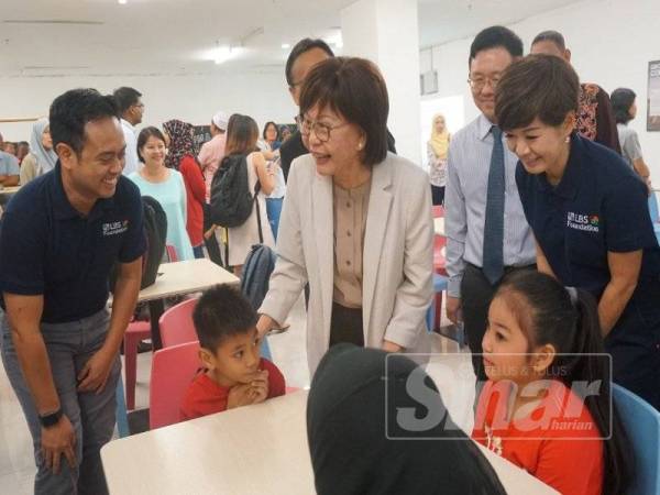Yee Kew (tengah) beramah mesra dengan murid yang telah mendaftar kelas tuisyen percuma di M3 Mall baru-baru ini.