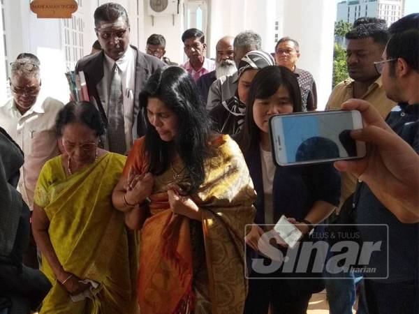 Meeriam (tengah) ketika hadir di Mahkamah Tinggi Ipoh hari ini.