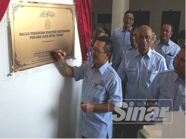Zulkifli menandatangani plak perasmian Kuarters Kakitangan Penjara Alor Setar hari ini.