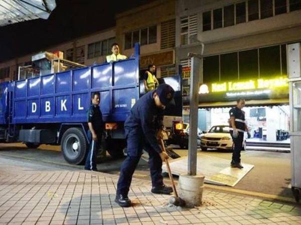 Anggota DBKL memecahkan halangan dipasang di ruang pejalan kaki pada Operasi Tegas Siri 33/2019.