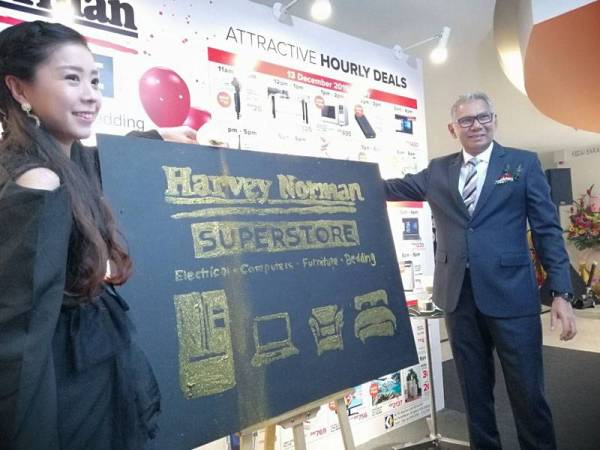 Kenneth menyempurnakan gimik perasmian pembukaan pusat jualan Harvey Norman di Ipoh Parade, hari ini.