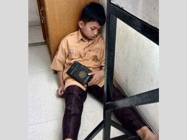 Kanak-kanak lingkungan usia 10 tahun itu nyenyak tidur di atas lantai bersandarkan tepi almari memegang al-Quran bersaiz kecil di tangannya.