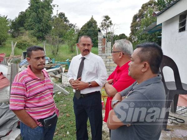 Abu Bakar (dua dari kiri) meninjau keadaan rumah penduduk Kampung Melayu Puncak Kundang yang telah dirobohkan Selasa lalu.