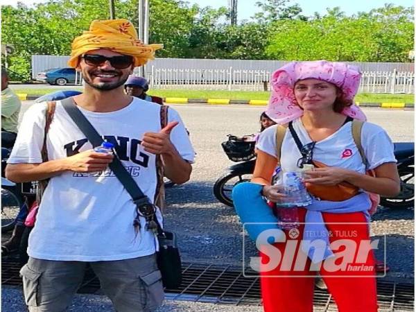 Pelancong asing turut mengenakan semutar.