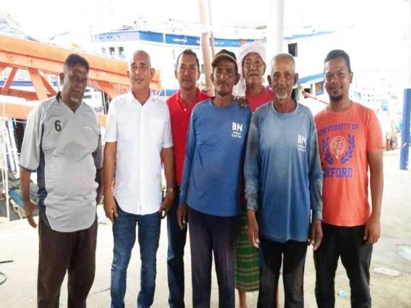 Mat Yasin (kanan) dan Shaharul Nizam (dua dari kanan) bersama beberapa nelayan Kuantan selepas tiba di jeti itu.