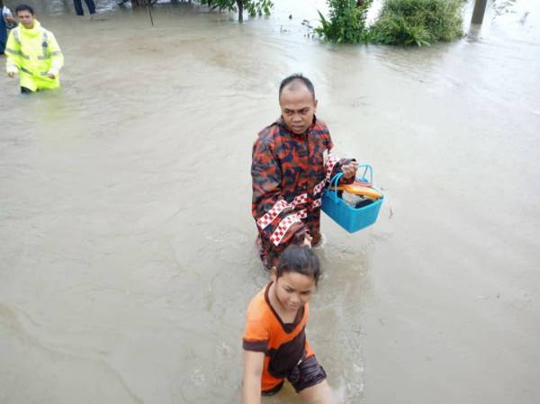 Anggota bomba memindahkan mangsa banjir selepas dua kampung di daerah Rompin dinaiki air petang tadi. FOTO: Ihsan bomba