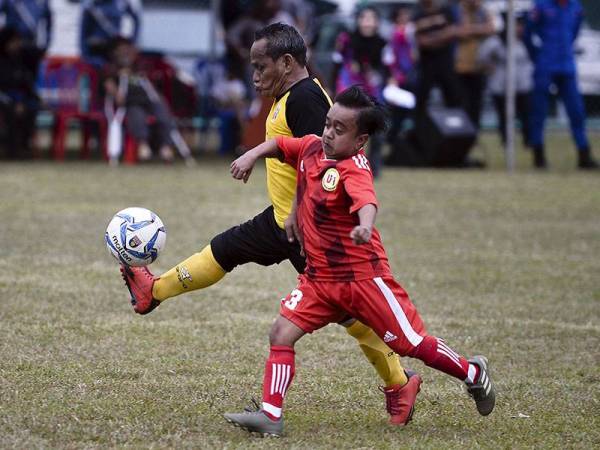 Pemain Pertubuhan Kebangsaan Orang Kerdil Malaysia, Mat Rawi Zulkifli (kiri) dicabar pemain Unit Berkarya Orang Mini Indonesia, M Lutfi Wijaksono (kanan) pada aksi persahabatan di Stadium Mini Majlis Sukan Negara, Kampung Baru hari ini. - Foto Bernama