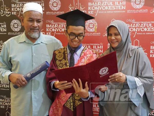 Mohamad Taufiq bersama ibu bapanya melihat diploma yang diperolehinya selepas berjaya menamatkan pengajian di KQT.