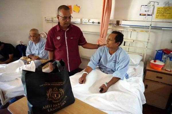 Shukor (tengah) bertanyakan khabar kepada Tuan Ismail Tuan Annur, 65, (kanan) yang sedang mendapatkan rawatan di Hospital Sultanah Maliha semasa Program Prihatin Parlimen Langkawi hari ini. - Foto: Bernama
