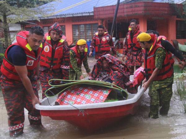 Anggota Bomba dan Penyelamat Renggam membawa mangsa banjir Bahrain Nuai (duduk), 70, bersama isterinya menaiki sebuah bot untuk dipindahkan ke Pusat Pemindahan Banjir (PPB) akibat kawasan yang makin terjejas disebabkan paras air yang semakin naik di Parit 3B Kampung Sungai Linau hari ini. -FOTO- BERNAMA