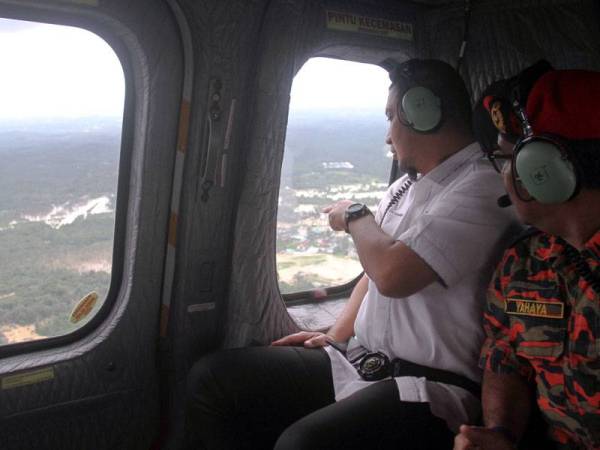 Dr Sahruddin (kiri) dan Yahaya (kanan) melihat keadaan banjir sekitar Kota Tinggi ketika menaiki helikopter Jabatan Bomba dan Penyelamat hari ini. Foto: Bernama