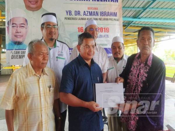 Azman (tengah) menerima memorandum daripada Che Ani (kanan) selepas Majlis Dialog Petani/Nelayan di Restoran Mega Kuning, Padang Lalang, Alor Janggus di sini semalam.