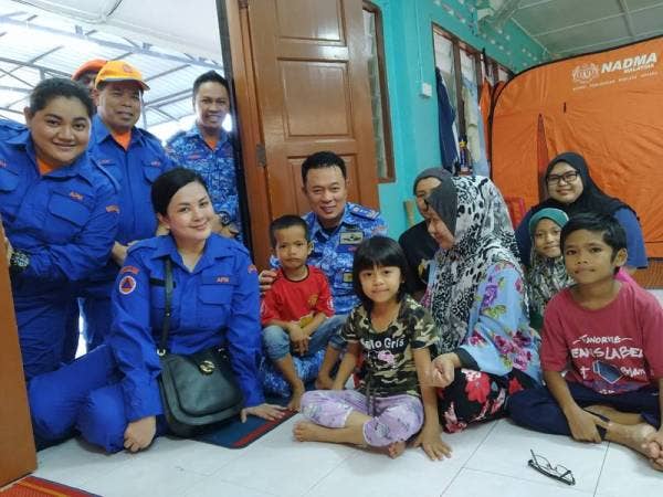 Tengku Kamarulzaman (duduk tiga dari kiri) berbual dengan mangsa banjir di PPS Balairaya Kampung Contoh, Kahang semalam.