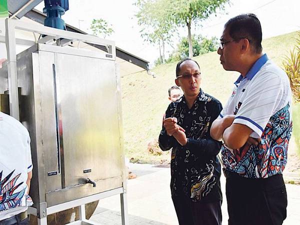 PENGARAH PSIS, Ishanuddin (kanan) mendengar penerangan mengenai inovasi yang menerima geran penyelidikan PPRN.