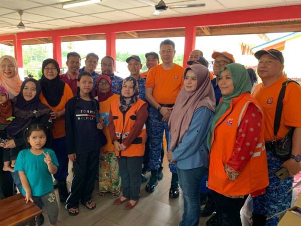 Tengku Kamarulzaman (tengah) bergambar bersama petugas dan mangsa banjir yang ditempatkan di PPS Mawai, Kota Tinggi, hari ini
