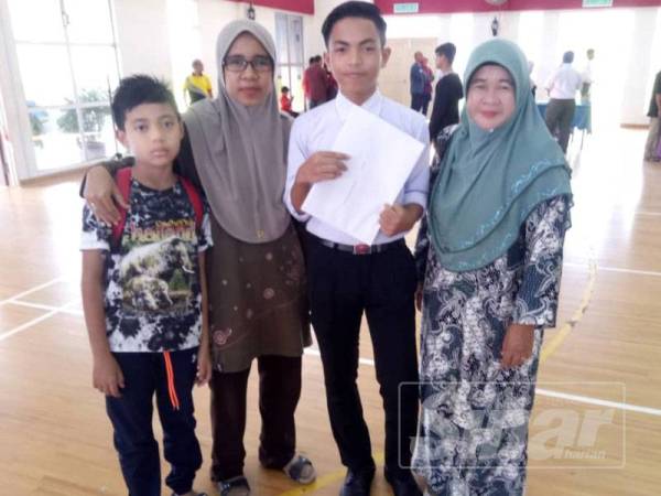 Faris bersama ibu saudara dan sepupu serta adiknya menunjukkan keputusan PT3 di sekolah.