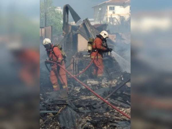 Anggota bomba membantu memadamkan kebakaran melibatkan sederet rumah setinggan di Kampung Kovil Hilir di sini petang tadi.