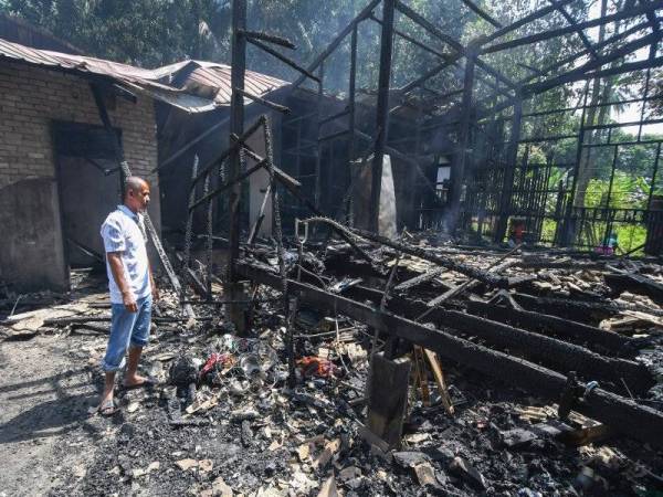 Mohd Zaini Ramli, 38, sugul mengenangkan nasibnya dan keluarga apabila rumah mereka musnah dalam kebakaran di Kampung Nechang hari ini. - Foto Bernama