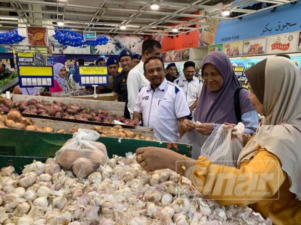 Adnan (tiga dari kanan) beramah mesra dengan pengguna yang membeli barangan dapur di Mydin Kubang Kerian hari ini.
