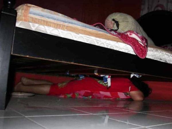 Seorang wanita warga Indonesia cuba bersembunyi di bawah katil bagi mengelak ditahan anggota penguat kuasa.