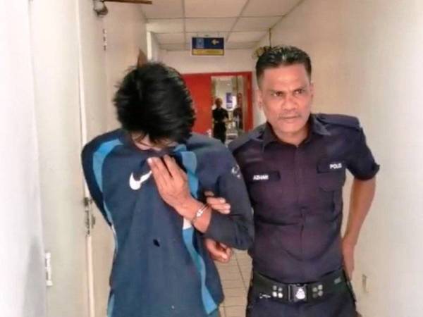 Mohd Fadlie diiringi polis sewaktu hadir di Mahkamah Majistret Kuala Terengganu hari ini.