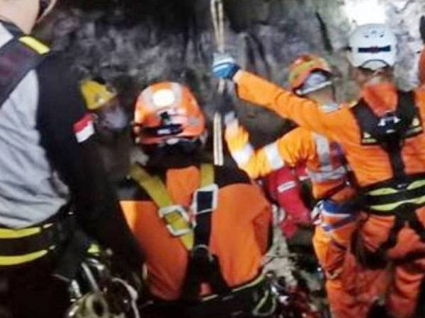 Anggota penyelamat bertungkus lumus mengeluarkan pelajar yang terperangkap di dalam gua akibat banjir. - Foto Agensi