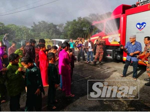 Ahmad Nazlan turut tidak ketinggalan menyirami peserta sebelum bermula program berkhatan.