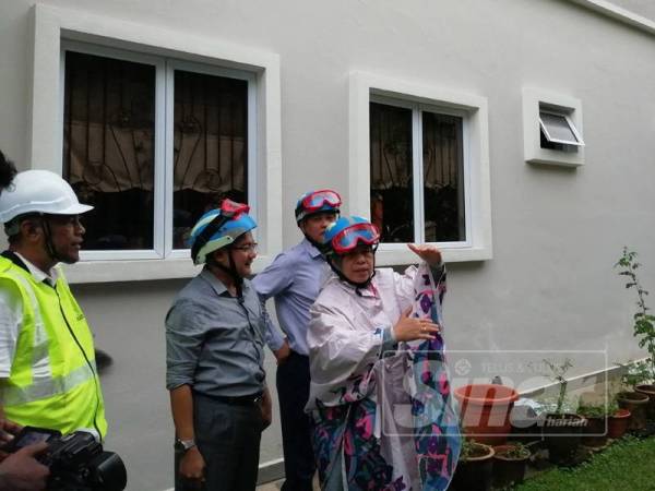 Zuraida (kanan) meninjau lokasi tanah mendap di Jalan Kelab Ukay di sini hari ini.